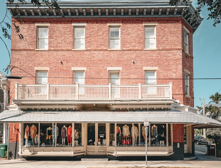 Charming red brick storefront with stylish clothing display on a sunny day.