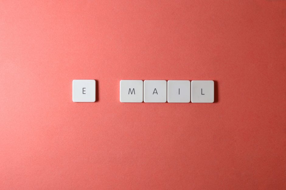 Pessoa sentada em frente a um computador com expressão surpresa, cercada por caixas de e-mail vazias, simbolizando o desafio de iniciar marketing de e-mail do zero.